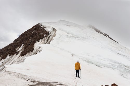 男子爬雪覆盖山 · 免费素材图片