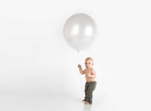 婴儿抱着白色的气球 · 免费素材图片