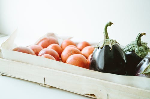 紫色茄子和圆形橙色水果的特写照片 · 免费素材图片