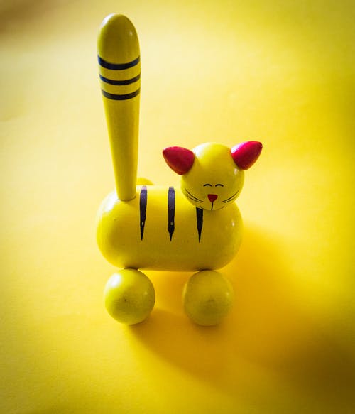 黄色顶部的黄色和红色猫雕像 · 免费素材图片