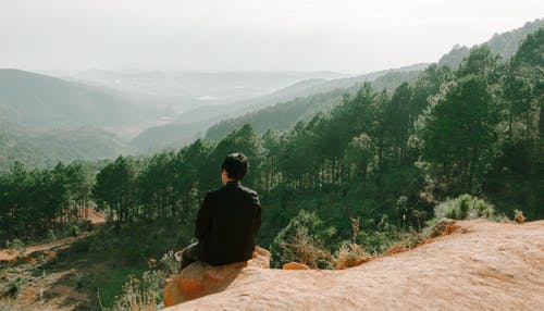 坐在山崖附近的人 · 免费素材图片