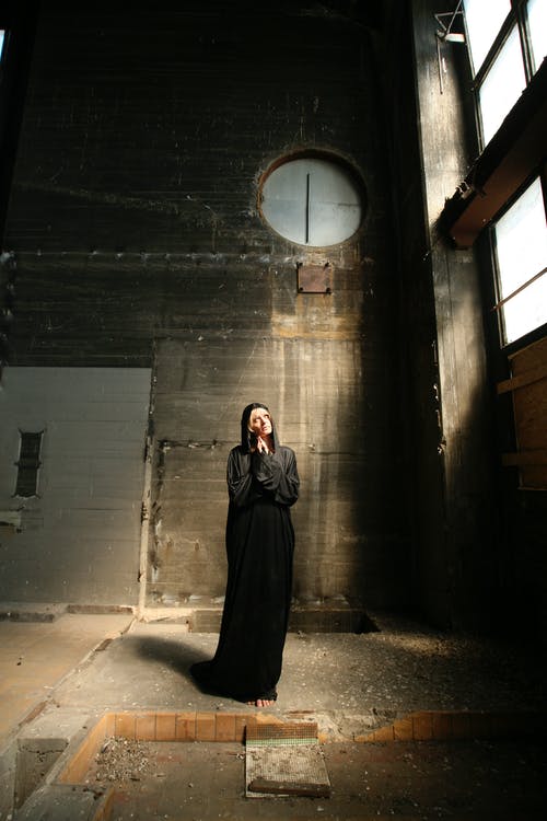 站在大楼里穿黑裙子的女人 · 免费素材图片