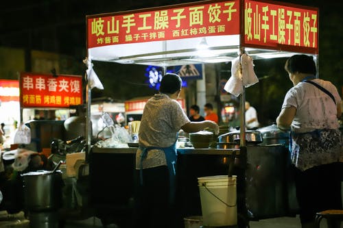 在食品摊位上做饭的人 · 免费素材图片