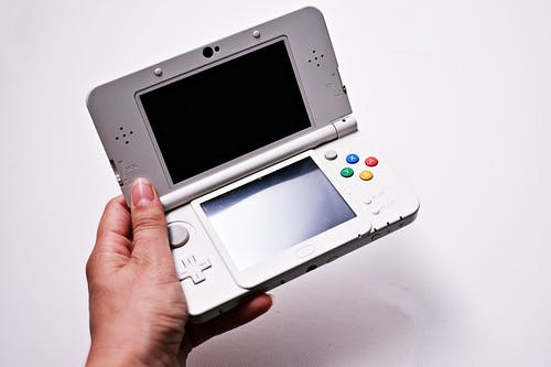 拿着灰色任天堂gameboy Advance的人 · 免费素材图片