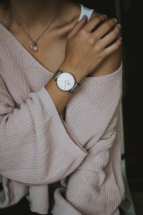 女人穿着米色钩针编织的毛衣和圆形白色模拟手表特写照片 · 免费素材图片