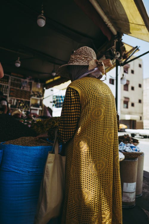 站在蓝色麻袋旁边的人 · 免费素材图片