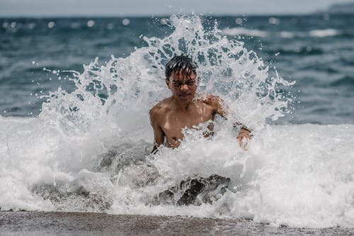 在海上游泳的男孩 · 免费素材图片