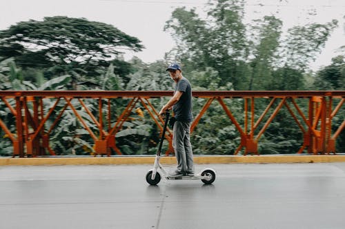 男子骑着小鸟电动滑板车 · 免费素材图片