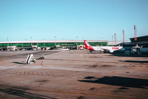 机场上的白色和红色飞机 · 免费素材图片