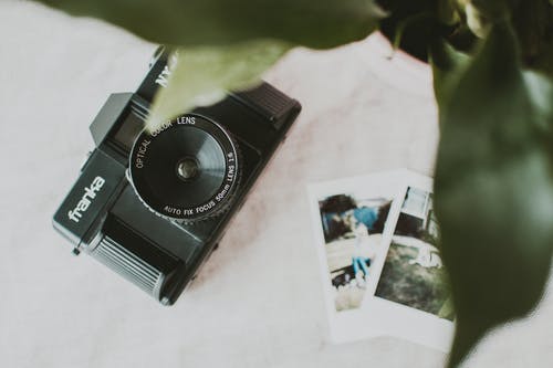 白色纺织品上的黑色弗兰卡相机 · 免费素材图片