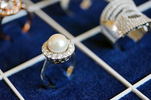 蓝色表面上的白色珍珠戒指 · 免费素材图片
