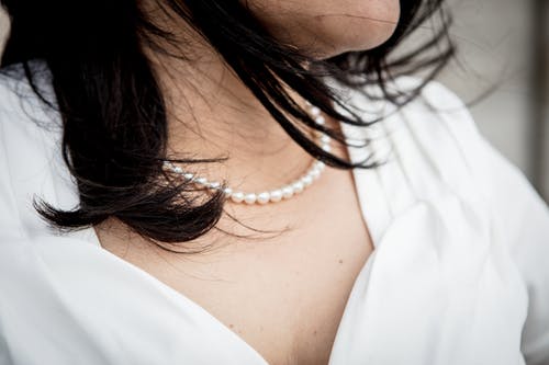 女人穿着串珠的白色珍珠项链的特写照片 · 免费素材图片