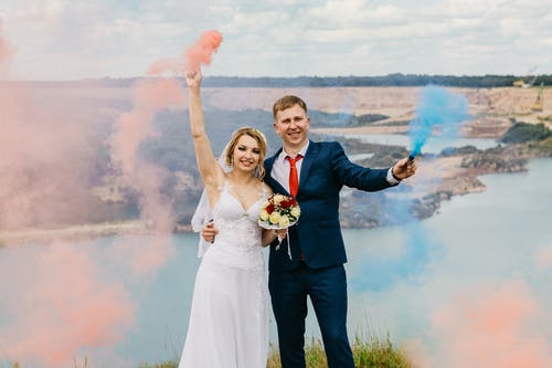 新娘和新郎拿着烟雾弹 · 免费素材图片