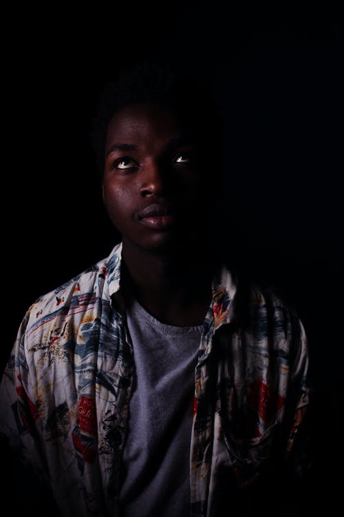 多彩多姿的衬衫的男孩与焦点照片上的深色背景 · 免费素材图片