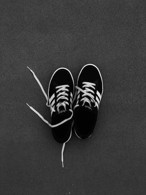一对灰色地板上的黑白阿迪达斯运动鞋 · 免费素材图片