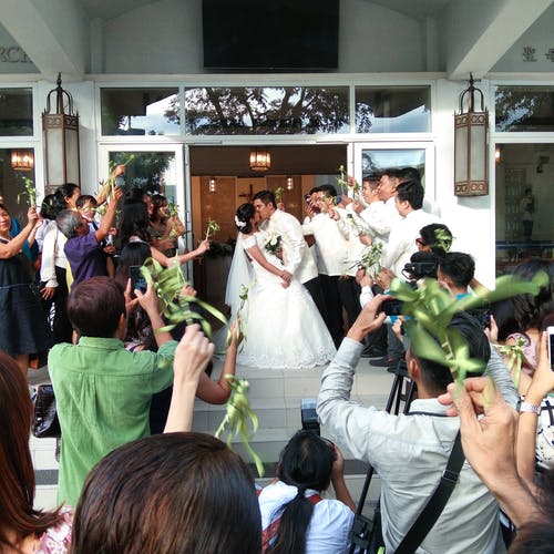 婚礼聚会包围的亲吻已婚夫妇的照片。 · 免费素材图片