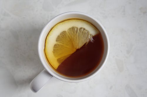 杯茶，柠檬片白色表面上 · 免费素材图片