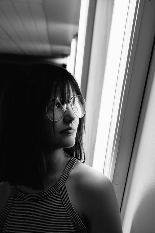 女人戴飞行员风格眼镜的灰度照片 · 免费素材图片
