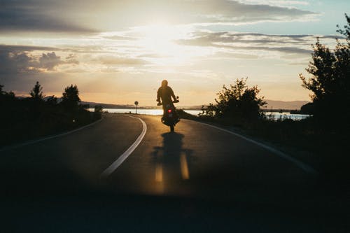 黄金时段的人骑摩托车 · 免费素材图片