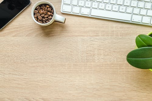 白色陶瓷棕色木制的桌子上的咖啡豆 · 免费素材图片