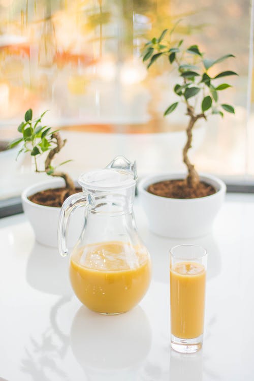 透明玻璃投手配黄色果汁 · 免费素材图片