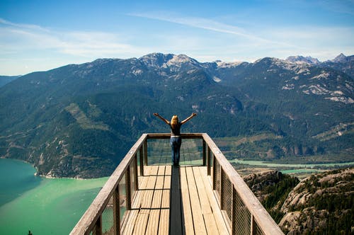 木制阳台俯瞰群山的人 · 免费素材图片