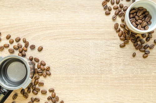 棕色咖啡豆在白色的塑料容器 · 免费素材图片