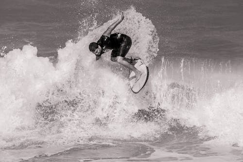 冲浪者在海浪上的灰度照片 · 免费素材图片