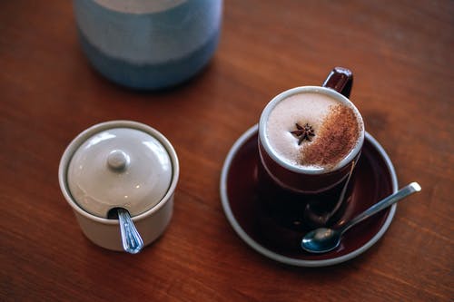 杯拿铁咖啡旁边白色容器 · 免费素材图片