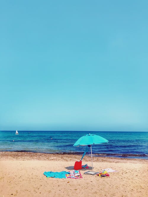 蓝绿色的阳伞在岸边 · 免费素材图片