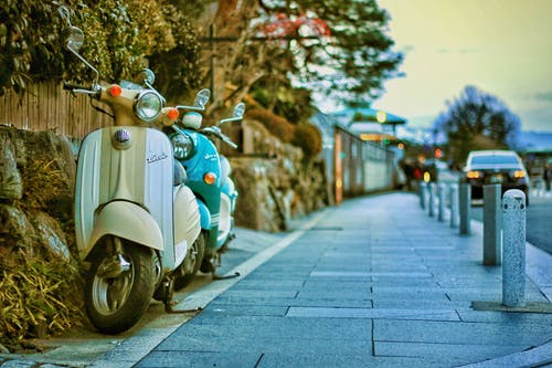 大街上的两个米色和蓝绿色摩托车 · 免费素材图片