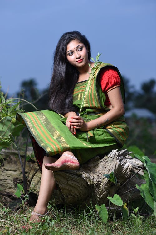 女人坐在日志上 · 免费素材图片