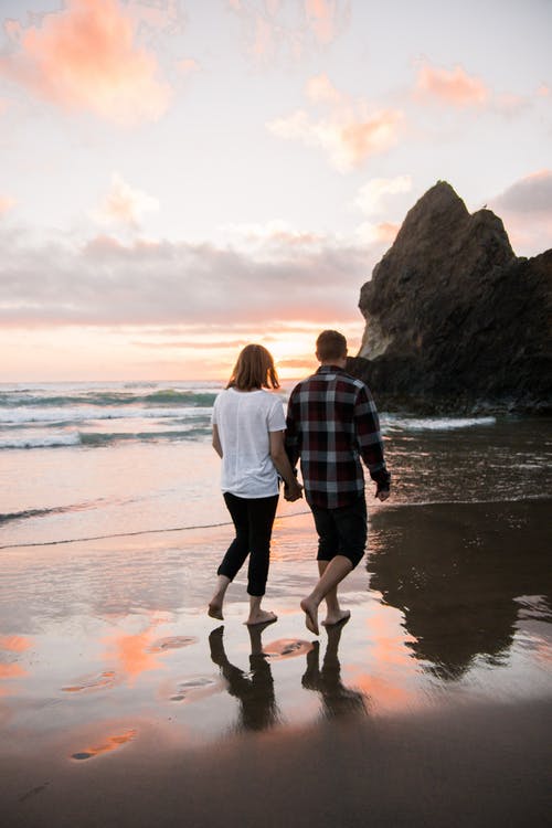 情侣牵手走在沙滩上 · 免费素材图片