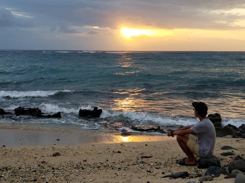 坐在海边看夕阳的男人 · 免费素材图片
