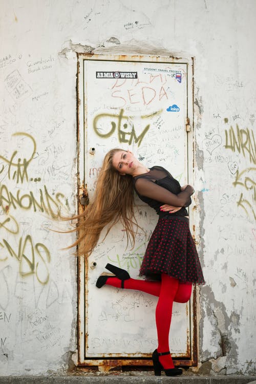 女人站在白色的门前右脚站着 · 免费素材图片