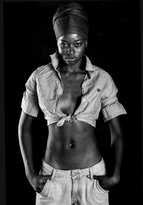 女人穿着作物顶部，她的手在她的口袋里的灰度照片 · 免费素材图片