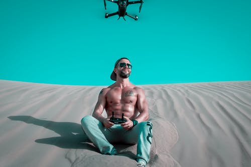 男子坐在防砂无人机 · 免费素材图片