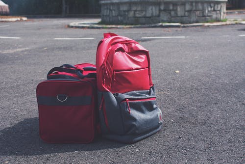 红色行李袋旁边的红色和灰色背包 · 免费素材图片