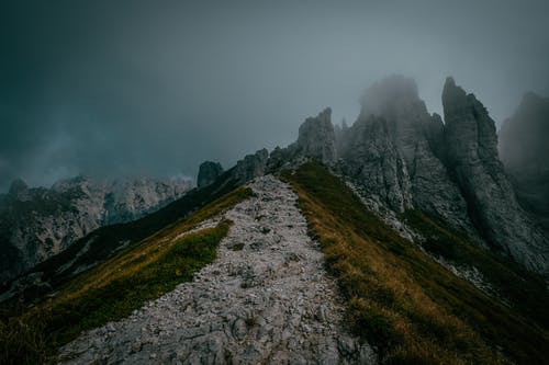 绿草田和灰云下的山 · 免费素材图片