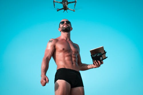 男子控制黑无人机的照片 · 免费素材图片