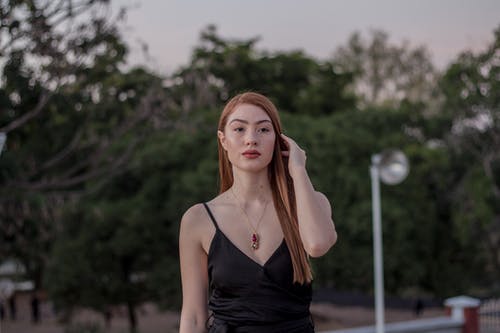 女人穿着黑色意大利面条表带上衣 · 免费素材图片