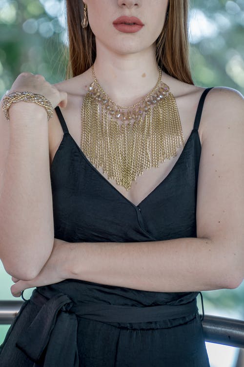 女人穿着金链围兜项链 · 免费素材图片