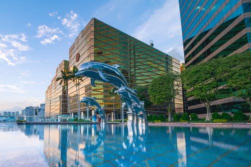 建筑物附近的水的三个蓝海豚雕像前面 · 免费素材图片