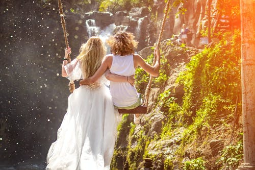 女人和女人骑木秋千在岩石形成 · 免费素材图片