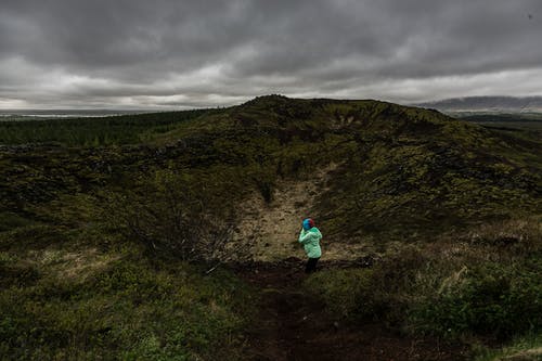 跪在绿色和黑色领域的人 · 免费素材图片