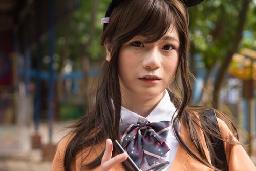 女人拿着智能手机的选择性焦点摄影 · 免费素材图片