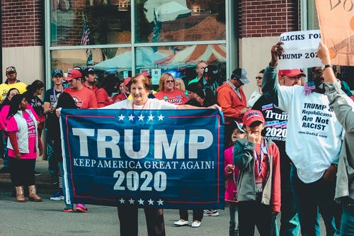 手持特朗普的女人再次使美国保持伟大2020年旗帜 · 免费素材图片
