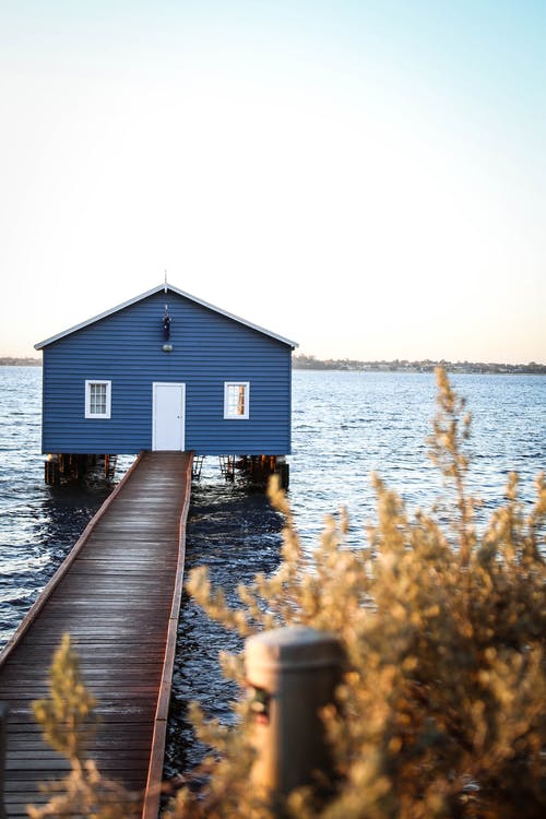 在蓝色和白色的天空下水面上的船坞的房子 · 免费素材图片