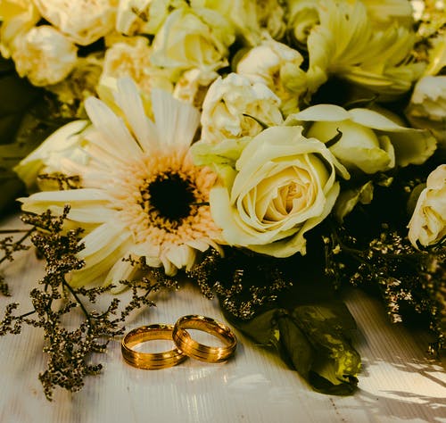 鲜花花束旁边的戒指 · 免费素材图片