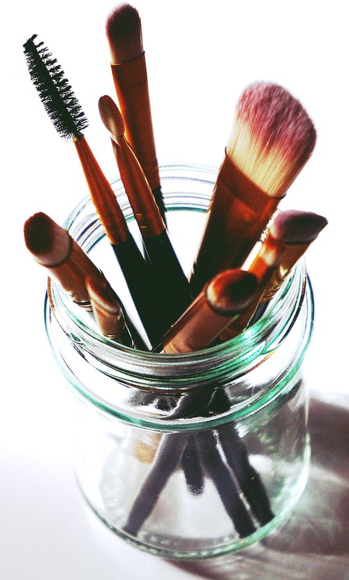 透明玻璃梅森罐子里的棕色化妆刷 · 免费素材图片